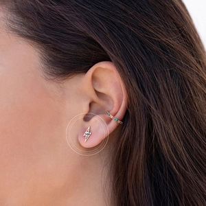 Close-up of colorful zircon lightning stud earring and rainbow ear cuff on model