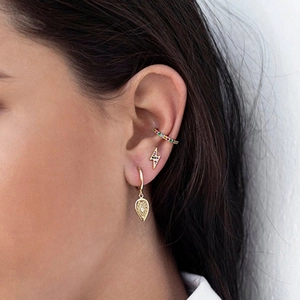 Close-up of model wearing colorful zircon lightning studs and golden rainbow ear cuffs