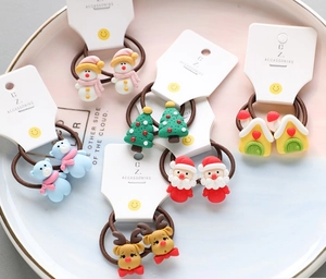 Flat lay of 12 Christmas hair ties featuring snowman, Santa, and reindeer resin charms