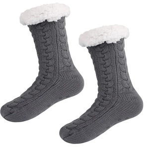 Detail of grey cable knit slipper socks with thick white fleece lining and anti-slip grips