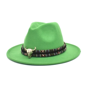 Detail of green felt fedora hat featuring a western bull head pendant and ethnic band