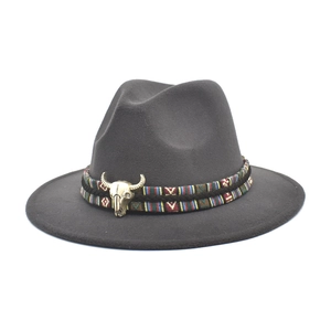 Detail of dark grey wool felt fedora with ethnic woven band and bronze bull skull emblem