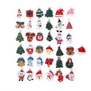 Flat lay of 35 assorted Christmas resin charms including Santas and snowmen on white background