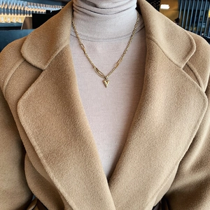 Collier élégant avec pendentif cœur doré et chaîne irrégulière porté par un mannequin