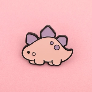Macro detail of cute pink enamel dinosaur stegosaurus brooch pin with purple accents