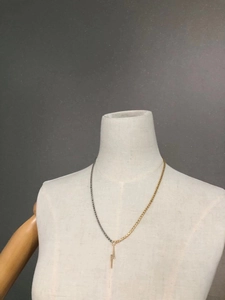 Detail of lightning bolt pendant necklace with mixed gold and silver link chains on mannequin