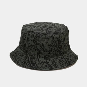 Détail d'un chapeau bob vert armée avec motifs de cactus noirs et texture en coton sergé