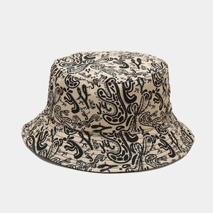 Vue détaillée d'un chapeau bob crème avec des graffitis noirs et motifs cactus