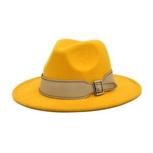 Macro shot of ginger yellow fedora hat showing felt texture and leather band with silver buckle