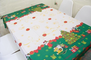 Detail of Christmas tablecloth featuring festive patterns like trees and gift boxes