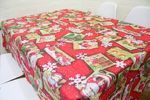 Close-up of festive red Christmas tablecloth with Santa, reindeer and tree patterns