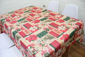 Detail of Christmas tablecloth with poinsettia patterns and ribbons on a dining table