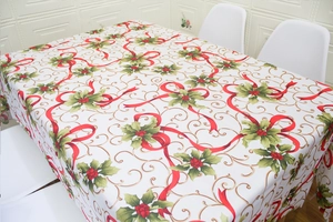 Detail of Christmas tablecloth with red bows, holly leaves, and gold swirls pattern
