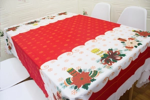 Close-up of festive Christmas tablecloth with red center, golden snowflakes and poinsettia border