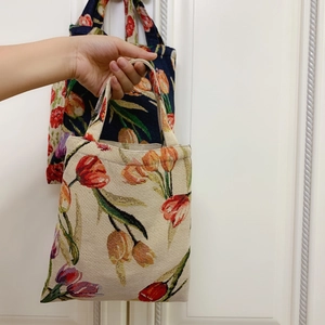 Detail view of vintage oil painting style tulip jacquard fabric on the handbag