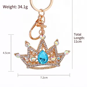 Sparkling rhinestone crown keychain in rose gold with blue teardrop crystal pendant