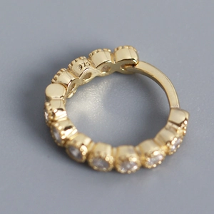Macro detail of gold S925 sterling silver hoop earring with paved zircon and 925 stamp