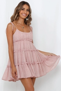 Détail de mini robe fleurie rose montrant des volants en mousseline et fines bretelles