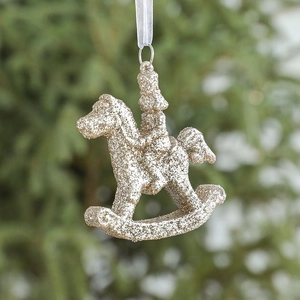 Glittery gold rocking horse Christmas ornament hanging on a festive tree branch