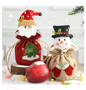 Detail of Christmas gift bags featuring 3D Santa and snowman dolls with drawstring closures