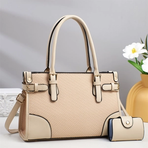 Detail of apricot handbag with woven leather texture and elegant gold buckle hardware