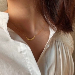 Elegant 925 sterling silver leaf necklace with gold moon pendant on a white shirt