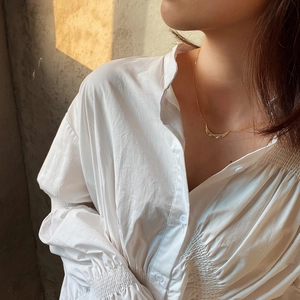 Detailed view of a gold crescent moon pendant on a minimalist necklace worn by a model