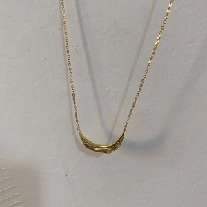 Detailed close-up of a 925 sterling silver leaf pendant with branch texture in gold finish