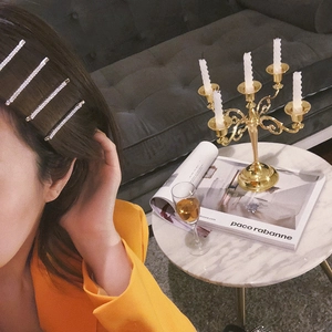Minimalist silver sparkling rhinestone hair pins set on elegant model wearing orange suit