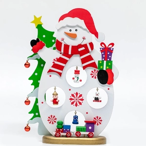 Handcrafted wooden snowman ornament with a small train and bell for Christmas tabletop decor