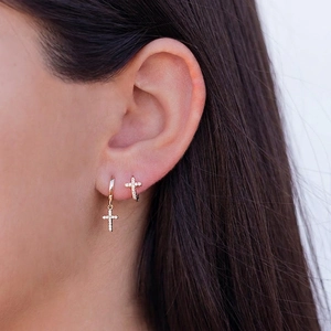 Fashionable gold hoop earrings with sparkling zircon cross pendants worn on ear