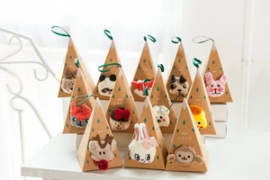 Close-up of animal-themed coral fleece socks in triangle gift boxes with green ribbons