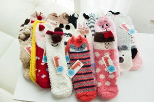 Close-up of thick coral fleece socks with cute cartoon animal patterns and plush texture
