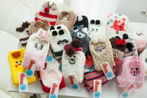 Close-up of assorted plush coral fleece Christmas socks with 3D cartoon animal designs