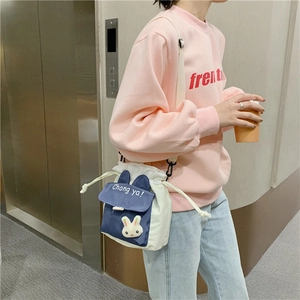 Detail of navy and beige canvas bucket bag with cute 3D bunny and drawstring closure