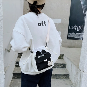 Detail of canvas bucket bag featuring black bunny ear flap and 'Chong ya!' slogan