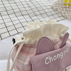 Close-up of cute pink plaid bucket bag with rabbit ears and Chong ya! lettering