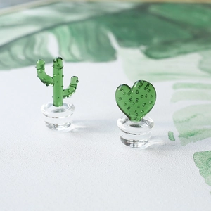 Handmade glass cactus decor set with green plants in clear bases on a desk