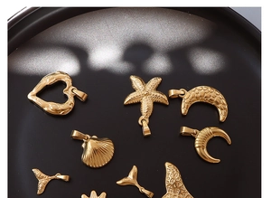 Detailed view of 18k gold plated ocean theme charms including moon and starfish on tray