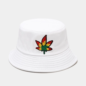 Gros plan d'une broderie de feuille colorée sur un chapeau bob en coton blanc