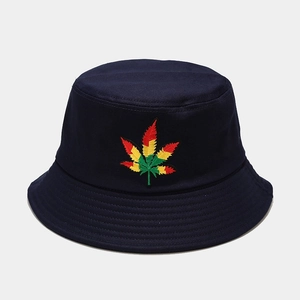 Gros plan détaillé de la broderie de feuilles sur un chapeau bob en toile de coton bleu
