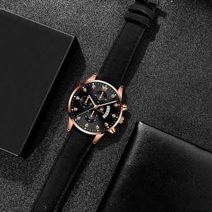 Detail of rose gold business watch featuring Roman numerals and faux diamond indexes