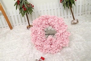 Detailed view of pink flocked Christmas wreath on a snowy background for holiday decoration