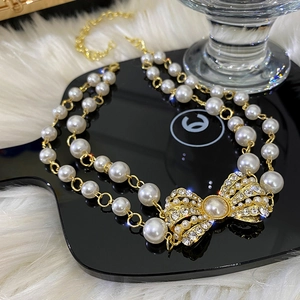 Double-layer pearl necklace with luxury rhinestone bow pendant on black display board