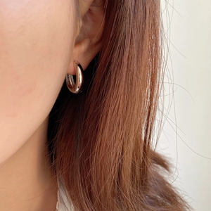 Close-up of minimalist chunky silver hoop earrings worn to show profile and scale