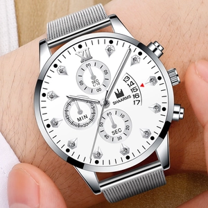 Gros plan d'une montre argentée pour hommes avec chiffres romains et index diamantés au poignet