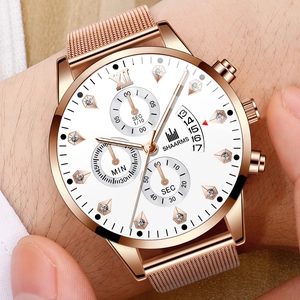 Gros plan d'une montre rose gold en maille avec chiffres romains et index diamant