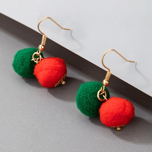 Detail of Christmas earrings featuring red and green plush pom-poms on gold hooks