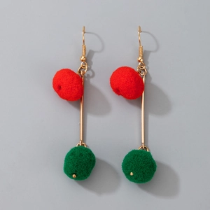 Close-up of festive Christmas cherry earrings with red pom-poms and green leaf details