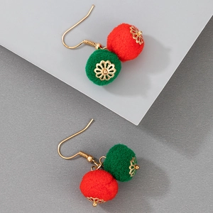 Detailed close-up of Christmas earrings with red and green pom-poms and golden charms